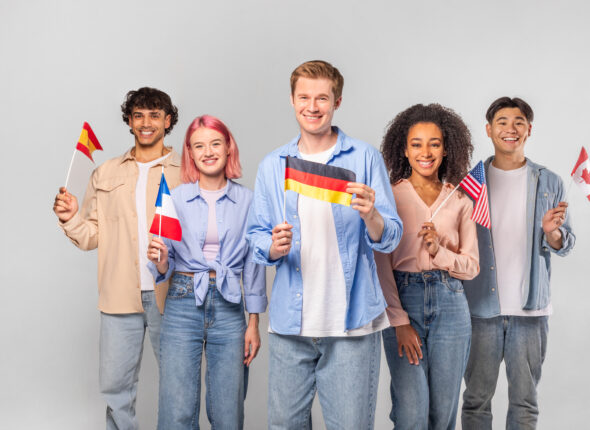 Diverse Group of Young Adults Holding Flags Against White Background